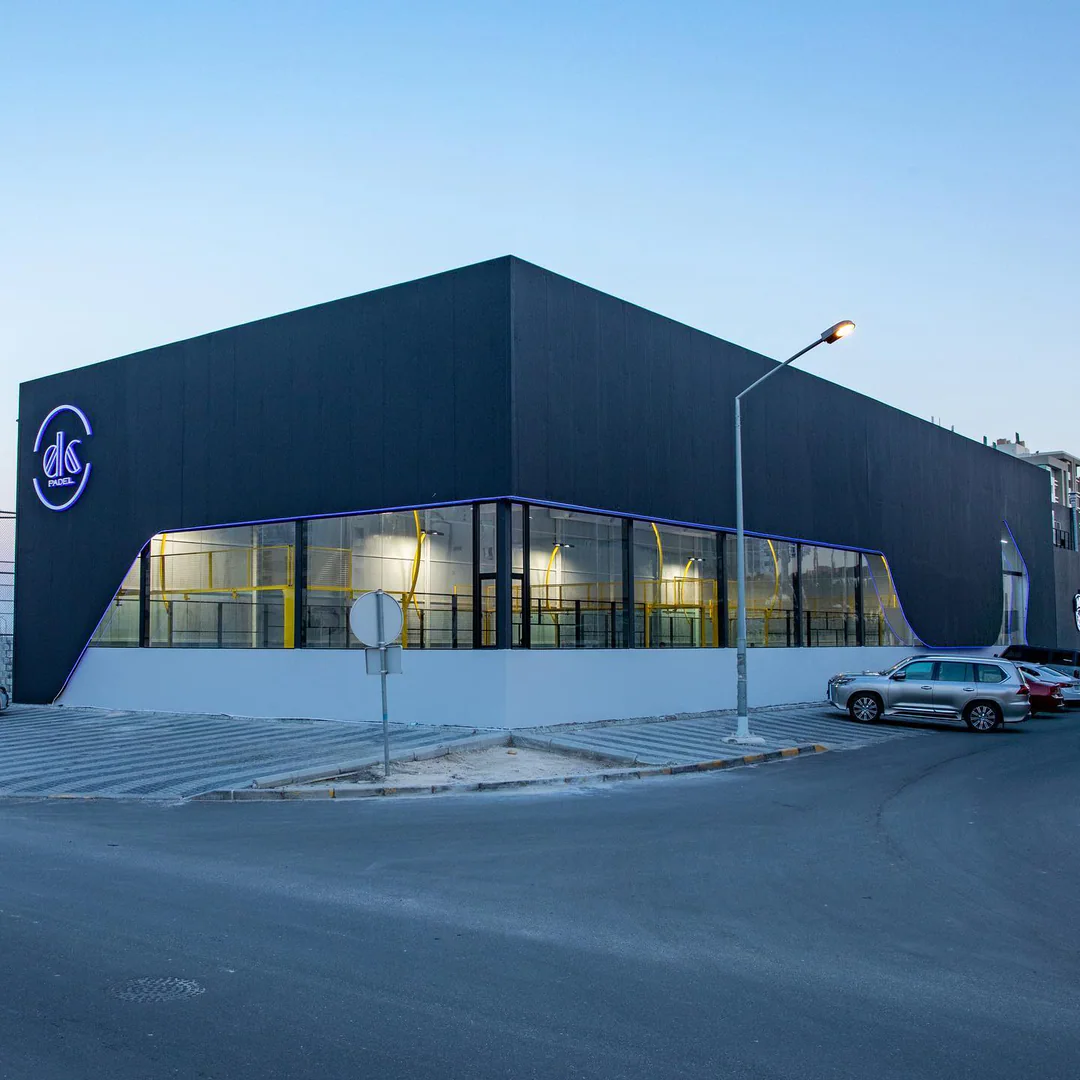 The black Padel DC building at dusk with the dc sign and lit glass band